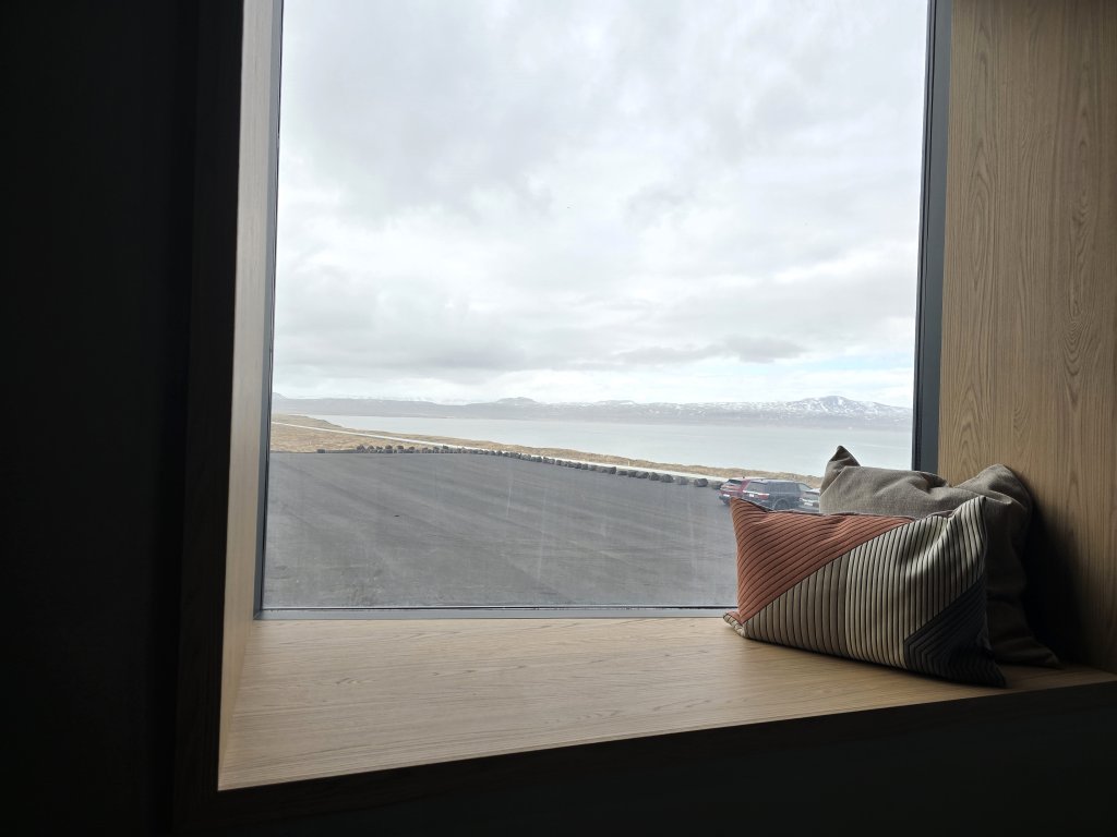 Horft út um glugga hótelsins á svörtum sandi.