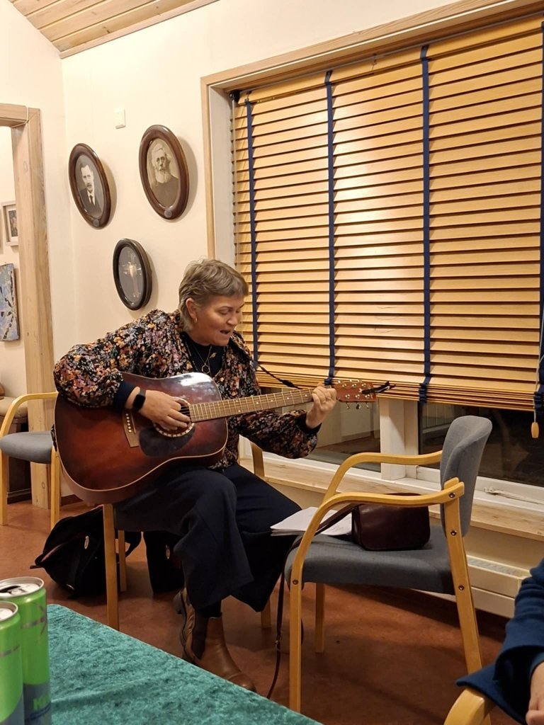 Jólalögin sungin og leikin. Magga Steina slær á gítarstrengina.