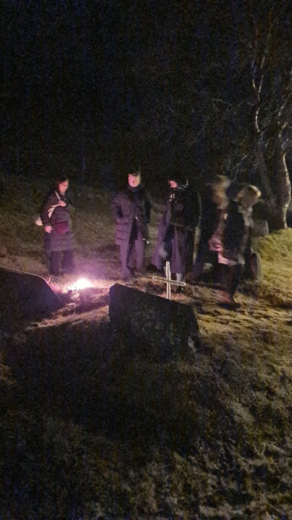 Kveikt á kertum og rósir lagðar á leiðið.